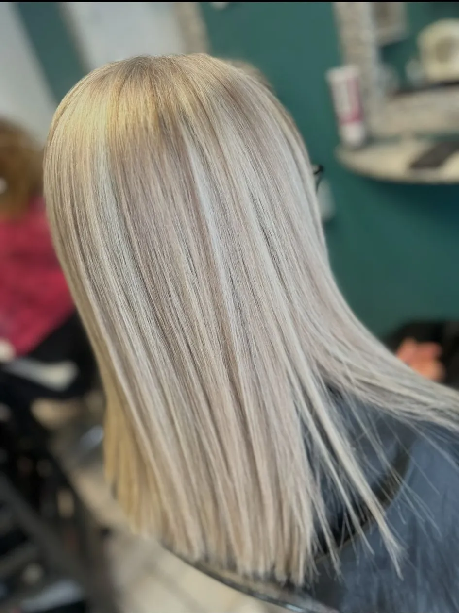 Sleek straight platinum blonde hair with a natural root blend