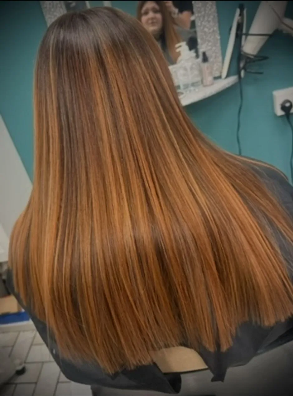 Long straight auburn hair with warm caramel highlights