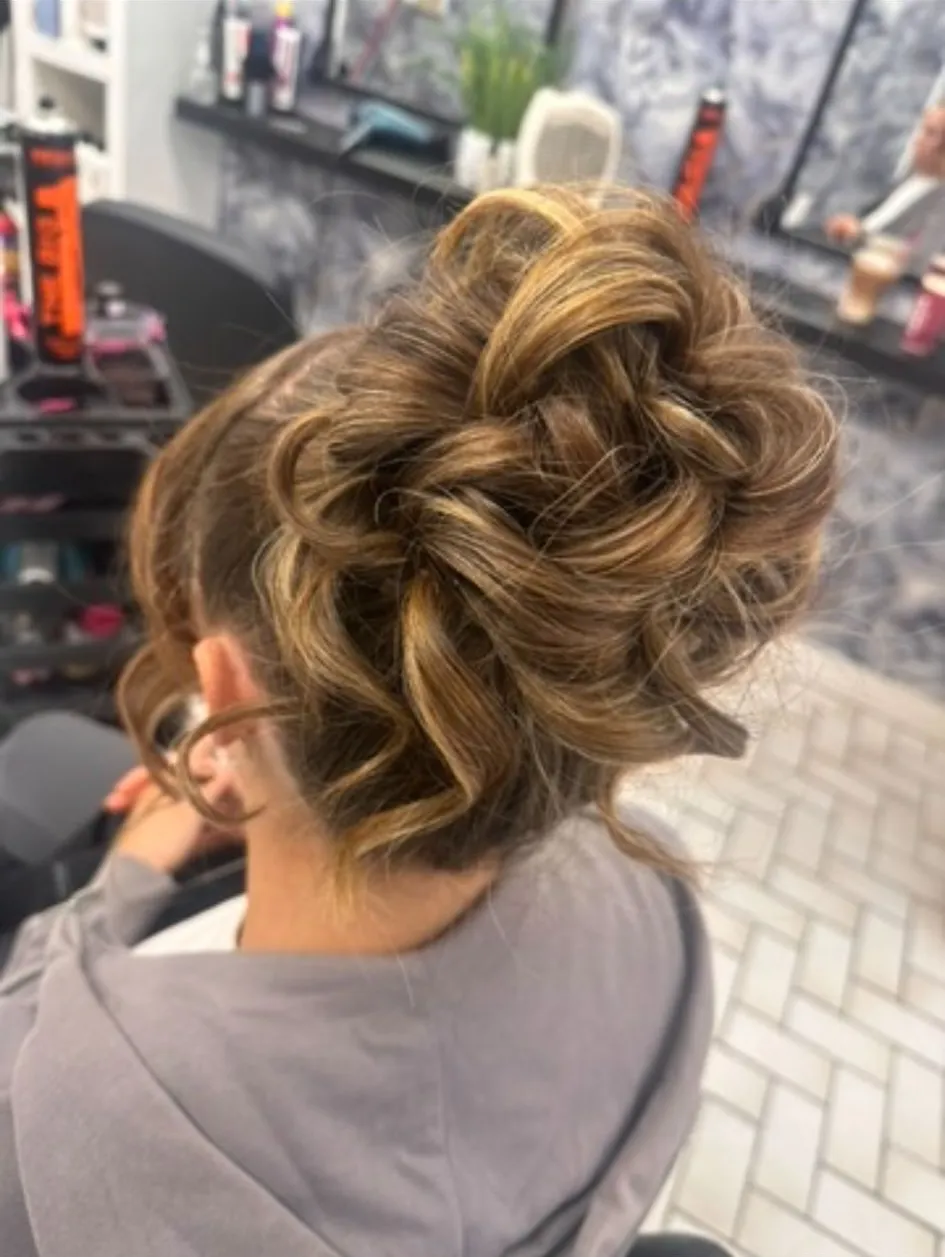 Elegant curled updo bun with loose face-framing tendrils